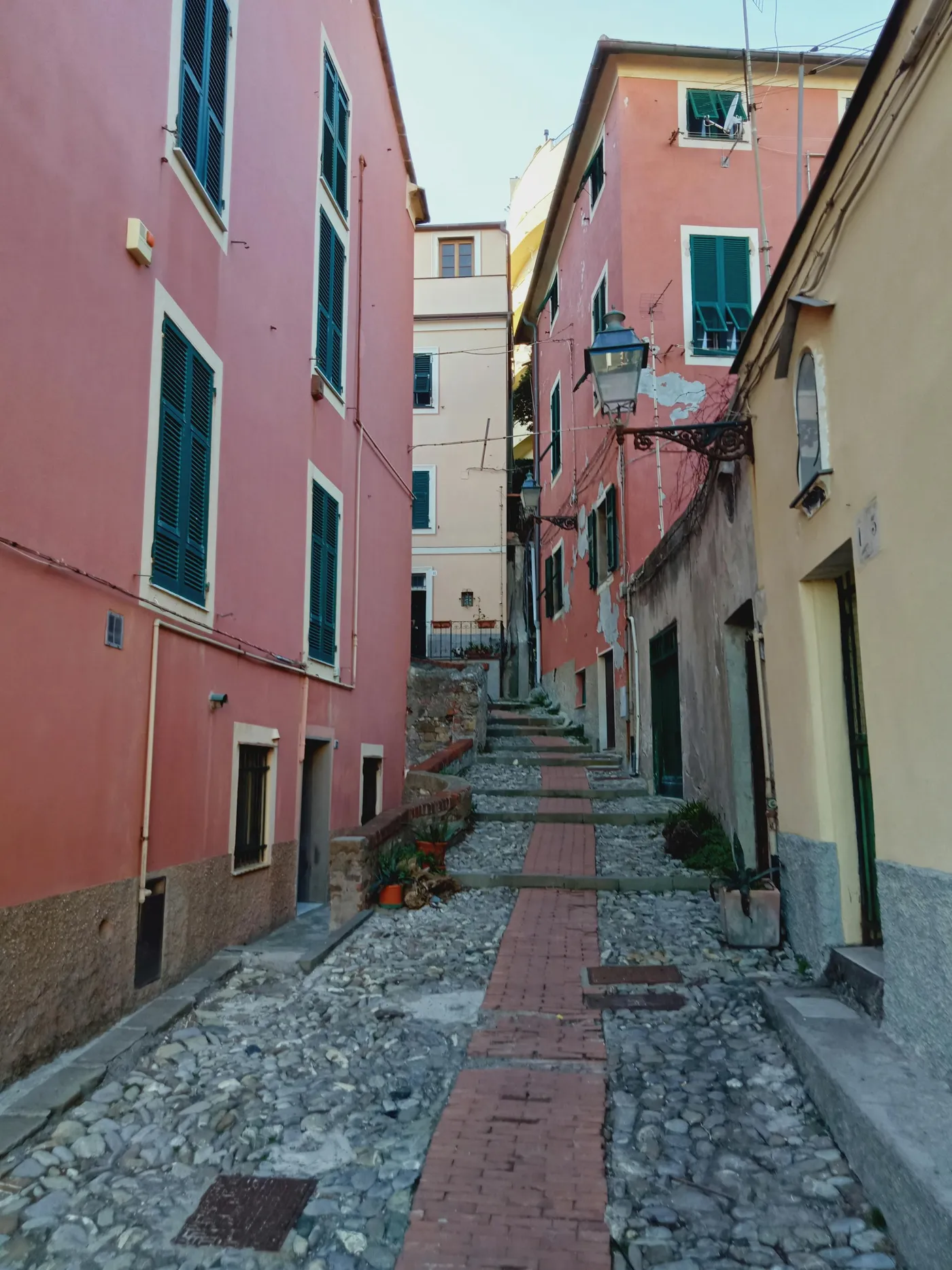 Vicolo stretto del caruggio di Cogoleto, con case colorate e botteghe storiche